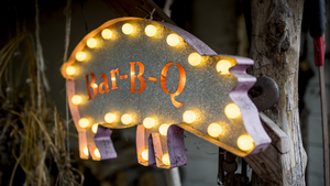 A lit sign, in the shape of a pig with the word Bar-B-Q in the middle.